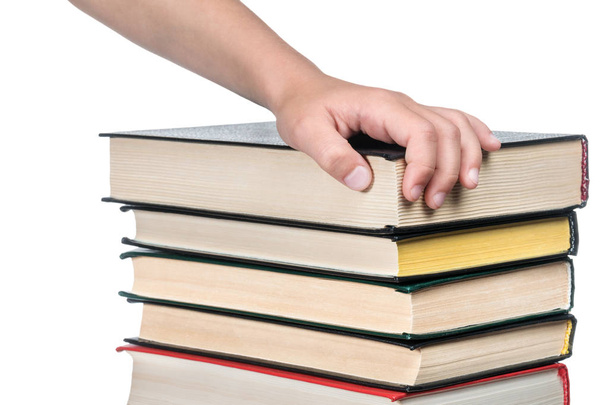 Child hand on a pile of books - Фото, изображение