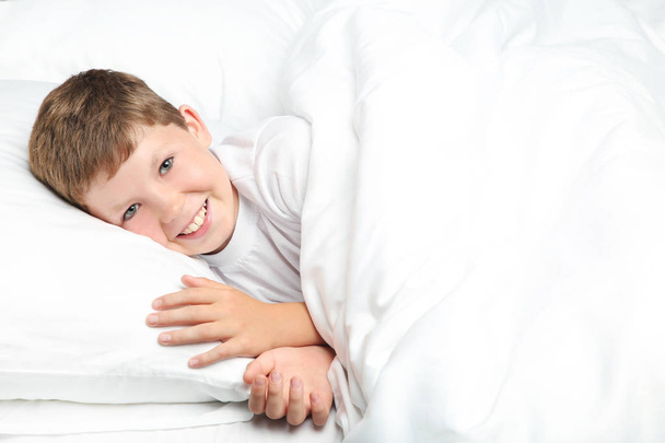 Young boy sleeping in white bed - Zdjęcie, obraz