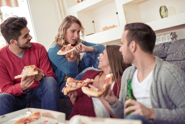 Amigos comendo pizza, bebendo cerveja e conversando
 - Foto, Imagem
