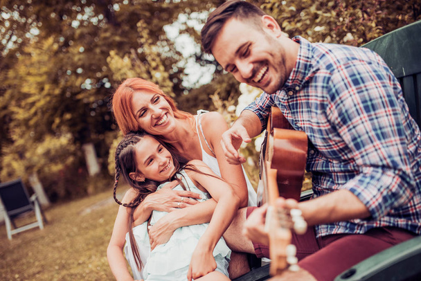 Οικογένεια παίζει κιθάρα σε εξωτερικούς χώρους - Φωτογραφία, εικόνα
