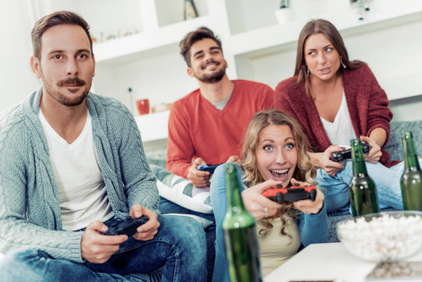 Friends playing video games at home - Fotó, kép