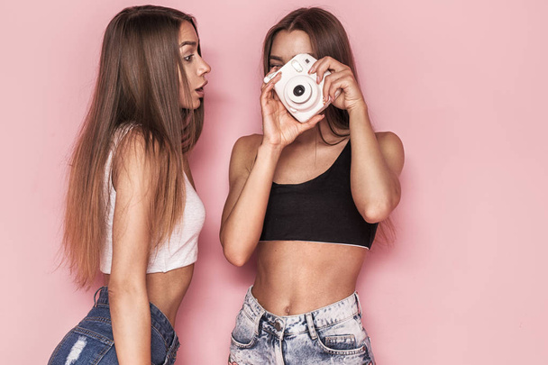 Young twins sisters taking photos. - 写真・画像