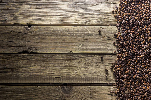 Kaffeebohnen auf alten Holzplanken. Ansicht von oben. flach lag. rustikaler Stil - Foto, Bild