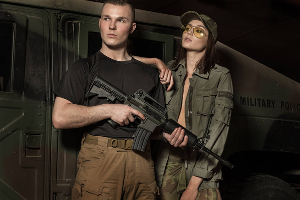 schöner Soldat mit Waffe und Frauen in seiner Nähe. - Foto, Bild