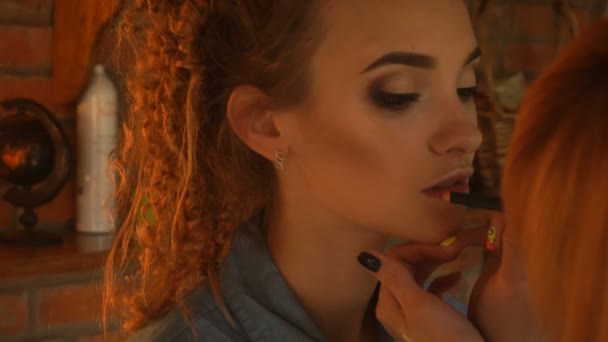 makeup artist paints her lips a beautiful young woman - Záběry, video