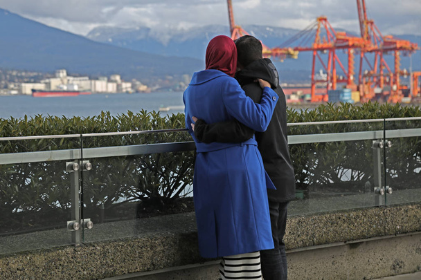 Νεαρό ζευγάρι μουσουλμάνων αγκάλιασμα βλέπουν αναπτυσσόμενη πόλη - Φωτογραφία, εικόνα