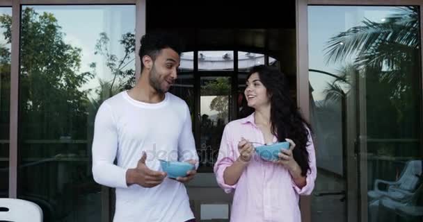 Couple Talking While Walking On Summer Terrace To Eat Breakfast, Happy Man And Woman Holding Plates With Oatmeal Outdoors - Materiaali, video