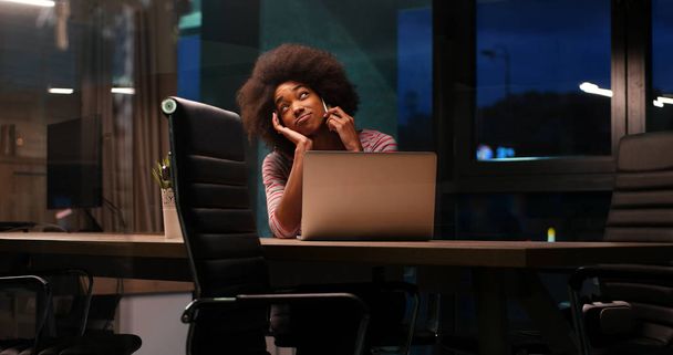 black businesswoman using a laptop in night startup office - Фото, зображення