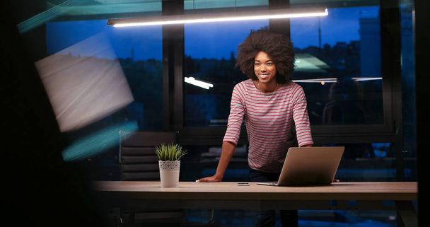 black businesswoman using a laptop in night startup office - Photo, image