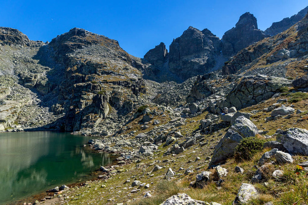 Niesamowity krajobraz straszny jeziora i szczytami Kupens, góry Riła - Zdjęcie, obraz