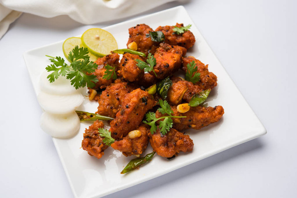 Курица 65 - пряная закуска во фритюре бар или быстрая закуска из Индии в сковороде на белом фоне, избирательный фокус
 - Фото, изображение