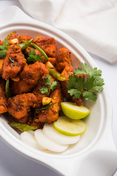 chicken 65 - würzige frittierte Bar-Vorspeise oder schneller Snack aus Indien in einer Pfanne vor weißem Hintergrund, selektiver Fokus - Foto, Bild