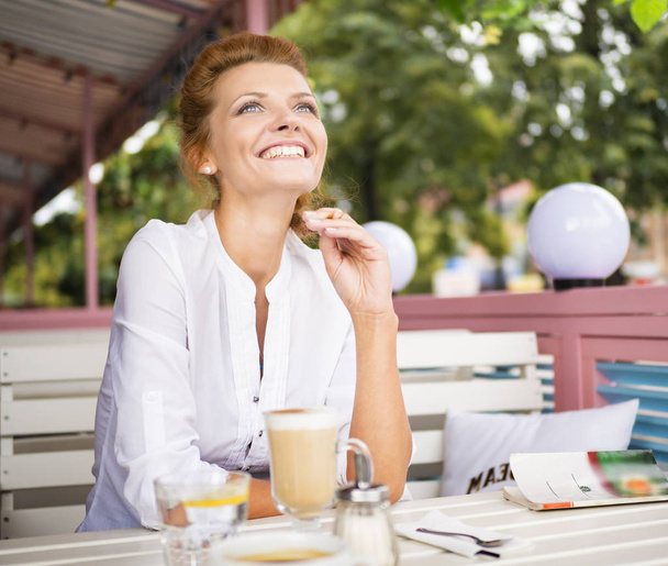 Kuva nuorten punaiset hiukset ja kaunis nainen kuppi kahvia nauraa kahvilassa
 - Valokuva, kuva