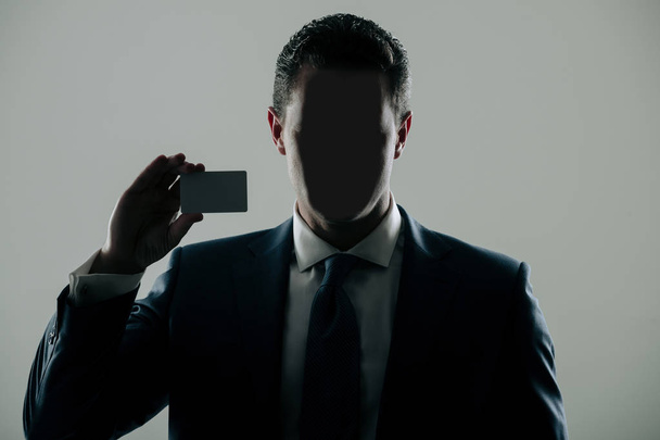 Faceless man holding blank business or bank card - Fotoğraf, Görsel