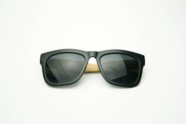 black sunglasses with wooden legs on white background - Photo, Image