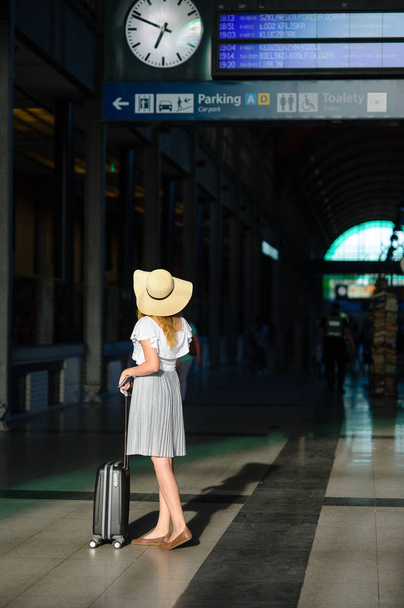 Meisje in zon-hoed in de wachtkamer van het station. - Foto, afbeelding