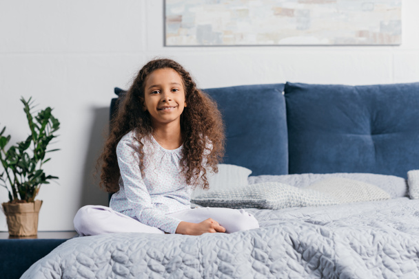 africká americká dívka sedící na posteli - Fotografie, Obrázek