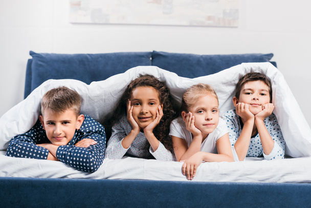 multicultural children lying in bed - Фото, зображення