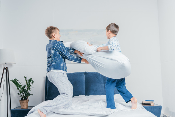 chicos teniendo pelea de almohadas
 - Foto, imagen