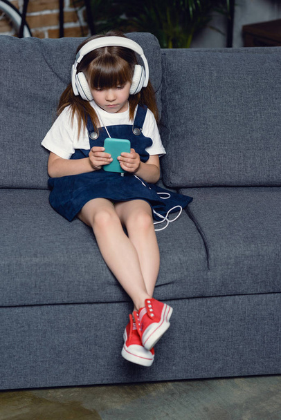 girl in headphones using smartphone - Fotografie, Obrázek