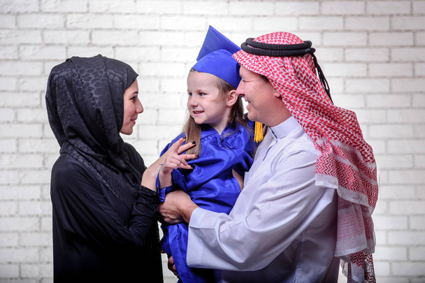 Арабська середнього у сім'ї позують з закінчення дочка початковій школі. - Фото, зображення