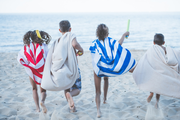 children with towels running on beach - Photo, Image