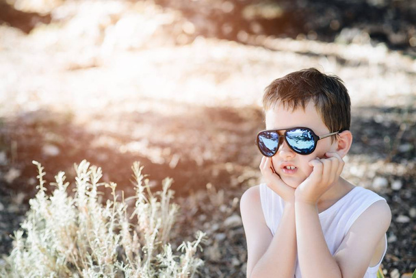 Triste petit garçon portant des lunettes de soleil
 - Photo, image