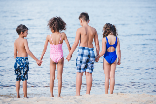 children standing on sandy beash - 写真・画像