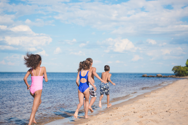 children running on sandy beach - Фото, изображение