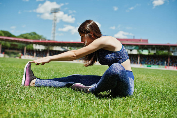 Portrait of a beautiful woman in sportswear stretching her muscl - Fotó, kép