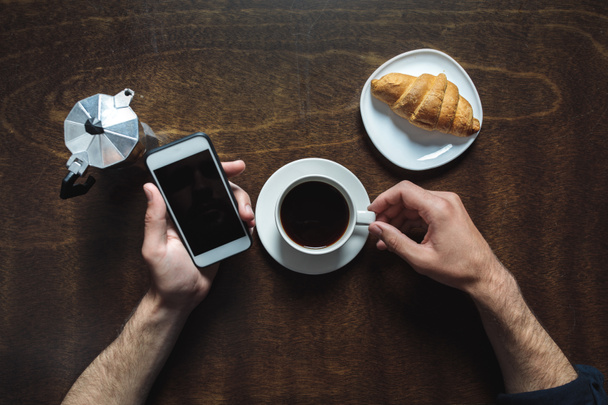 using smartphone and drinking coffee - Photo, Image