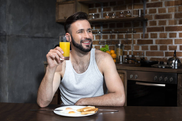 bearded young man drinking juice - Foto, afbeelding