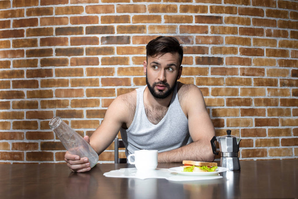 Junger Mann mit Milchflasche auf Küche - Foto, Bild