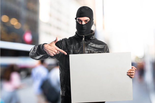 Voleur tenant une pancarte vide
 - Photo, image