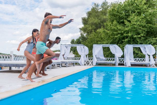 gente multiétnica saltando a la piscina
  - Foto, imagen