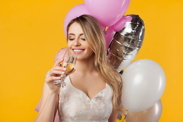 Nainen ilmapallojen kanssa juo samppanjaa
 - Valokuva, kuva