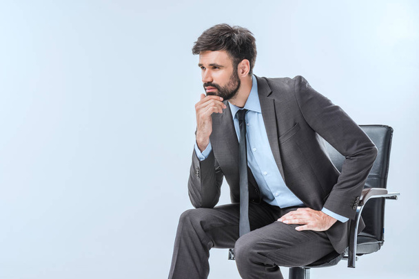 pensive businessman sitting on chair - Photo, Image
