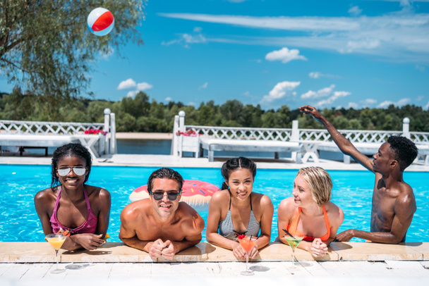 personas multiétnicas con cócteles en la piscina
  - Foto, imagen