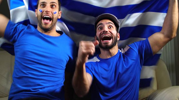 Amigos griegos celebrando con bandera de Grecia
 - Foto, Imagen