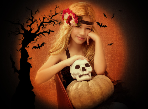 halloween kid girl with pumpkin and skull smiling - Фото, изображение