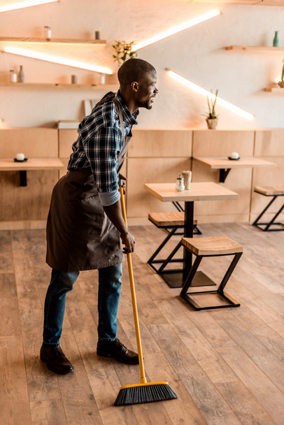 man brooming in coffee shop - Фото, зображення