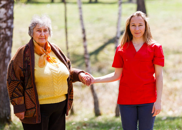 高齢の女性と若い介護者 - 写真・画像