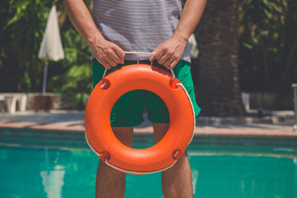 Close up of man holding lifebuoy at the poolside - Fotografie, Obrázek