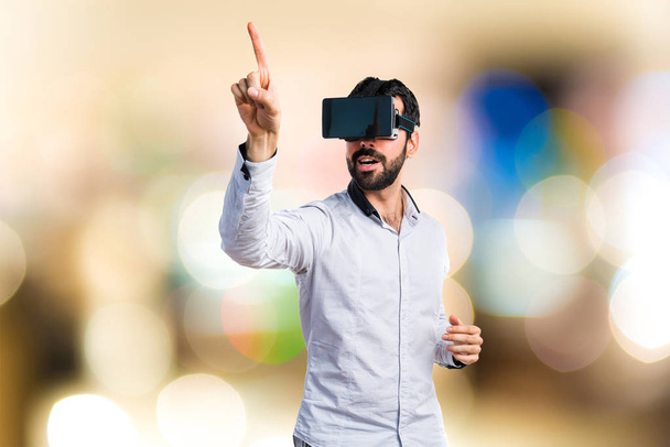 Hombre usando gafas VR tocando en pantalla transparente
 - Foto, Imagen