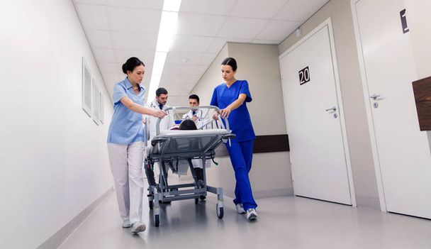 medics with woman on hospital gurney at emergency - Zdjęcie, obraz