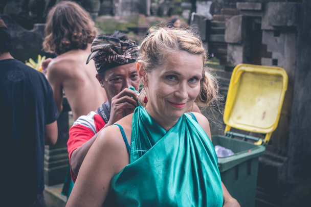 European woman at Pura Tirta Empul temple during a religious ceremony in Tampa, Bali, Indonesia. - 写真・画像