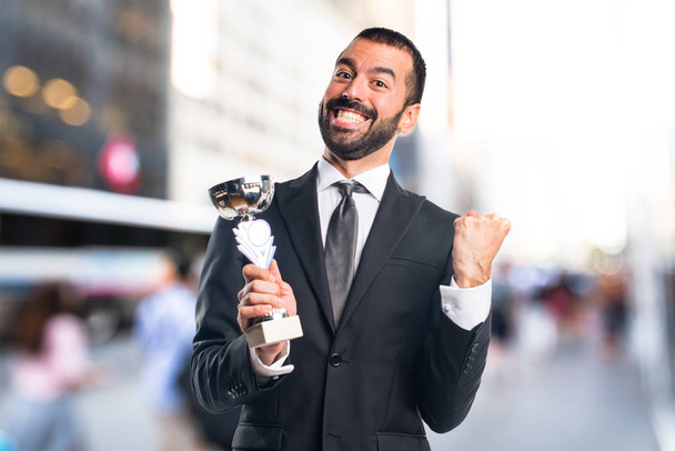 бизнесмен, держащий трофей - Фото, изображение