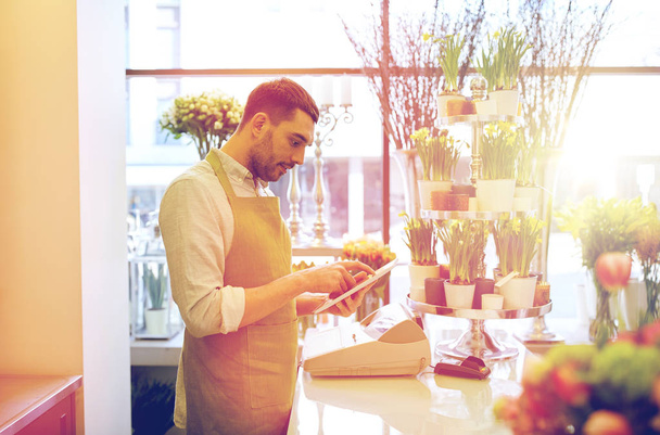 man with tablet pc computer at flower shop - Foto, Imagem
