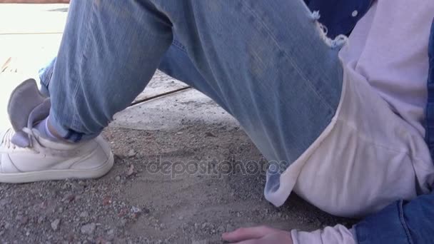 Рудий модний молодий чоловік сидить на підлозі даху в джинсовому одязі і рвані джинси
 - Кадри, відео