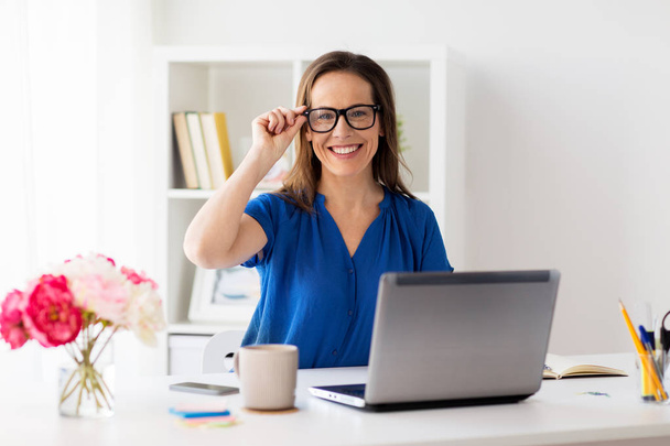 mujer feliz con el ordenador portátil que trabaja en casa u oficina
 - Foto, Imagen
